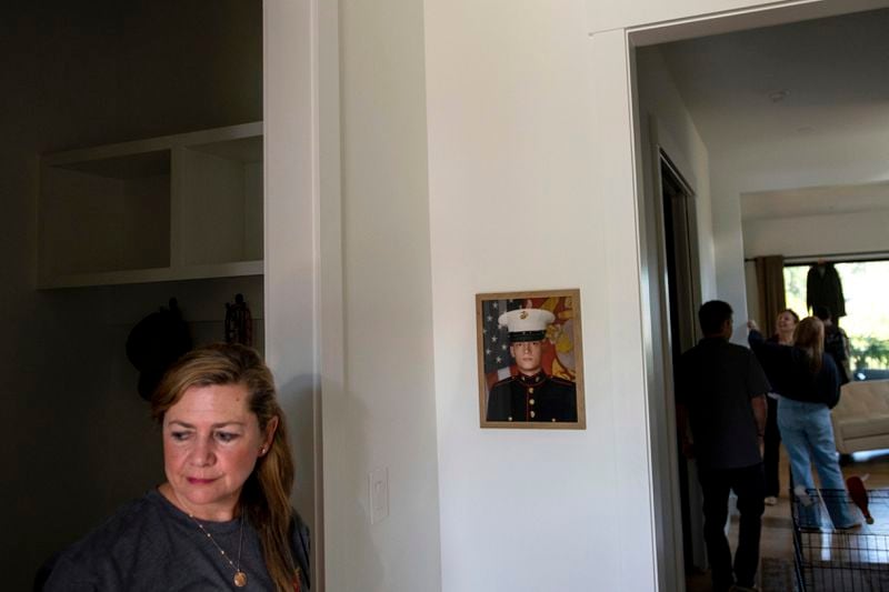 Alexia Collart stands near a photograph of her son, Marine Corporal Spencer R. Collart, at her home, in Arlington, Va., Thursday, June 19, 2024. Her son was killed along with two other Marines when the MV-22B Osprey aircraft they were on crashed during drills on a north Australian island on August 27, 2023. (AP Photo/Rod Lamkey, Jr.)