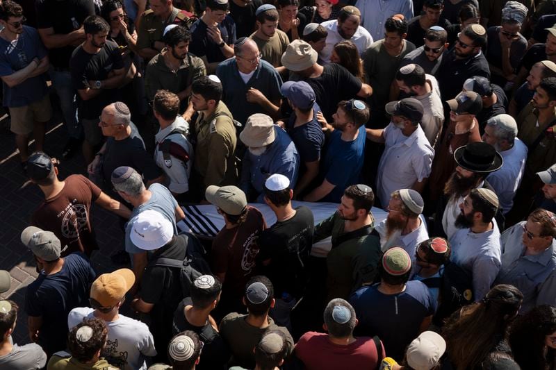 Relatives and friends of Yonatan Deutsch, who was killed in a drive-by shooting in the Israeli-occupied West Bank, carry his body during his funeral at a cemetery in Jerusalem, Monday, Aug. 12, 2024. (AP Photo/Leo Correa)