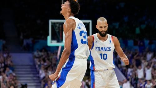 Victor Wembanyama, of France, celebrates with Evan Fournier, after making a basket and being fouled by Brazil in a men's basketball game at the 2024 Summer Olympics, Saturday, July 27, 2024 in Villeneuve-d'Ascq, France. (AP Photo/Mark J. Terrill)