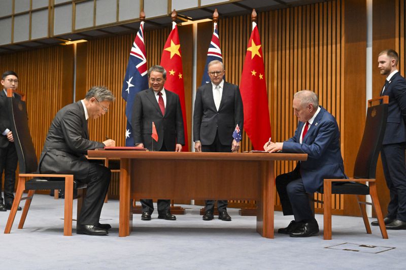 China's Premier Li Qiang, center left, and Australia's Prime Minister Anthony Albanese, center right, join China's Minister of Commerce Wang Wentao, second left, and Minister for Trade Don Farrell at a signing ceremony at Parliament House in Canberra, Monday, June 17, 2024. (Mick Tsikas/Pool Photo via AP)