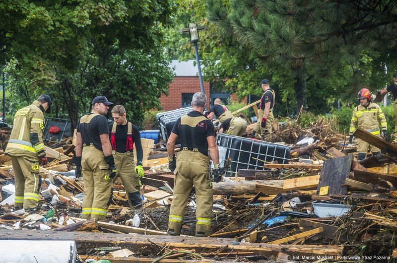 This handout photo provided by the Polish fire department, shows firefighters removing piles of debris dumped in the streets by high flood wave that is passing through southwestern Poland, in Glucholazy, Poland, on Tuesday, Sept. 17, 2024. ( Marcin Muskala/KG PSP via AP)