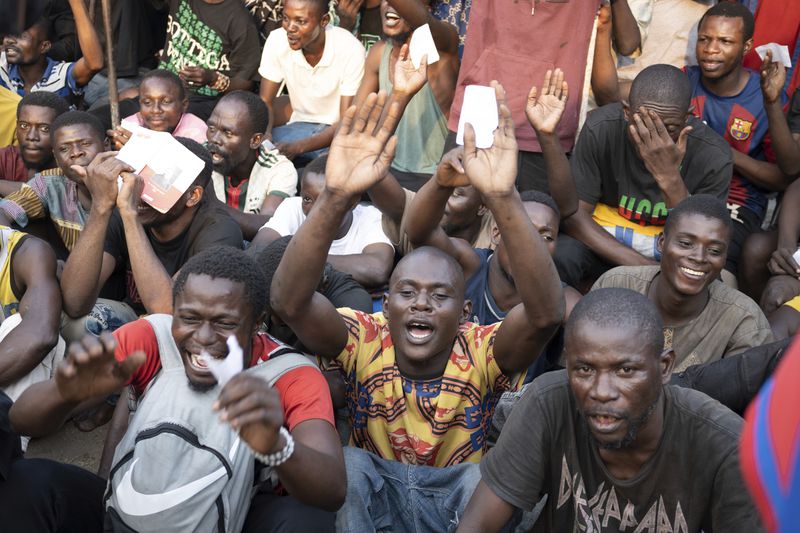 Some of the 600 prisoners released from Democratic Republic of the Congo's capital Kinshasa's Makala Central Prison react Saturday, Sept. 21, 2024. (AP Photo/Samy Ntumba Shambuyi)