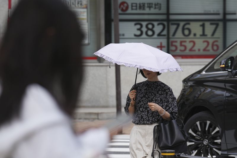 A person walks near an electronic stock board showing Japan's Nikkei index at a securities firm Tuesday, Sept. 24, 2024, in Tokyo. (AP Photo/Eugene Hoshiko)