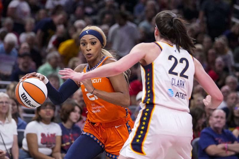 Connecticut Sun guard DiJonai Carrington (21) drives on Indiana Fever guard Caitlin Clark (22) in the first half of a WNBA basketball game in Indianapolis, Wednesday, Aug. 28, 2024. (AP Photo/Michael Conroy)