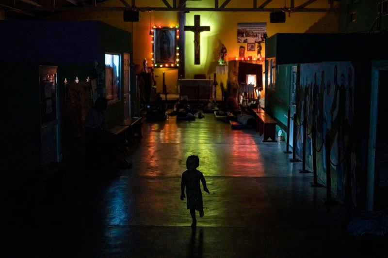 A young migrant runs through the Peace Oasis of the Holy Spirit Amparito shelter where migrants sleep on the floor on mats in Villahermosa, Mexico, late Friday, June 7, 2024. After the head of Mexico's immigration agency ordered a halt to deportations in December, migrants have been left in limbo as authorities round up migrants across the country and dump them in the southern Mexican cities of Villahermosa and Tapachula. (AP Photo/Felix Marquez)