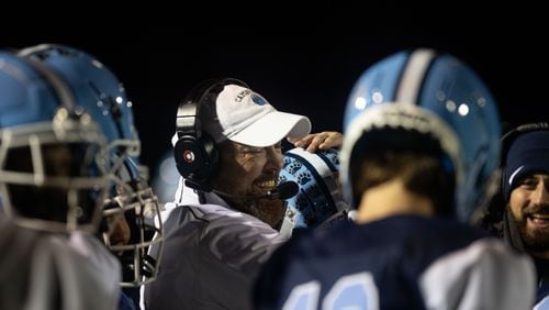 Cambridge Head Coach Craig Bennett hugs players during a GHSA high school football game between Cambridge and South Paulding at Cambridge High School in Milton, GA., on Saturday, November 13, 2021. (Photo/Jenn Finch)