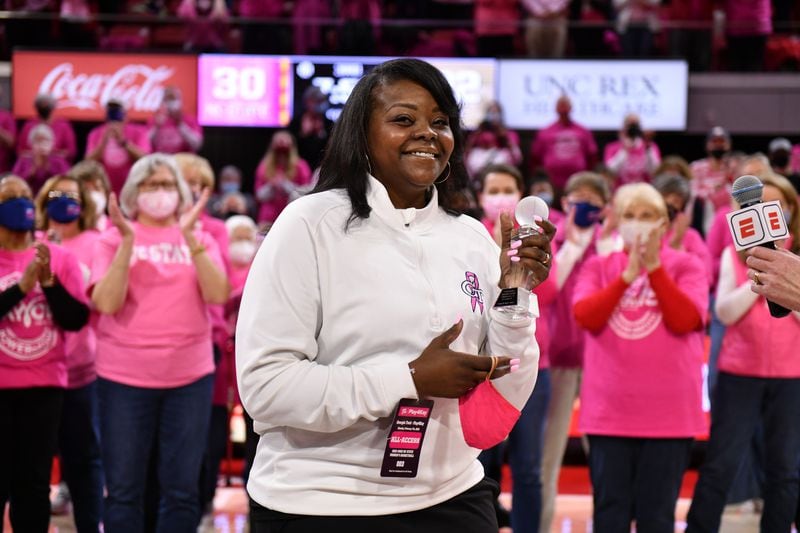 Georgia Tech associate head coach Tasha Butts acknowledges applause at Tech's game at N.C. State Feb. 7, 2022 in Raleigh, N.C. Butts was honored at halftime of the game, which was a fundraiser for the Kay Yow Cancer Fund, for her own fight against breast cancer. “I never thought I’d be standing here and battling this, but you guys give me so much hope,” Butts said during the ceremony. “This game right now is against two teams, but at the end of the day, there is something more important that we’re all fighting, and there’s so much more that they’re playing this game for.” (Chris Downey/N.C. State)