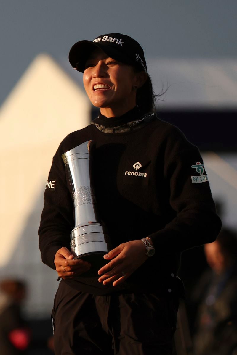 Lydia Ko, of New Zealand, poses for the media's she holds the trophy as Champion golfer after winning the Women's British Open golf championship, in St. Andrews, Scotland, Sunday, Aug. 25, 2024. (AP Photo/Scott Heppell)