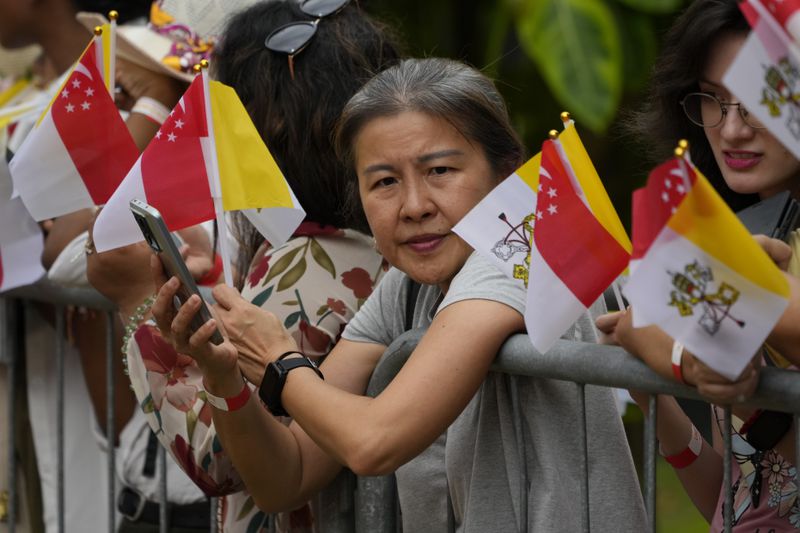 Volunteers wait to greet Pope Francis on his arrival in Singapore, Wednesday, Sept. 11, 2024. (AP Photo/Vincent Thian)