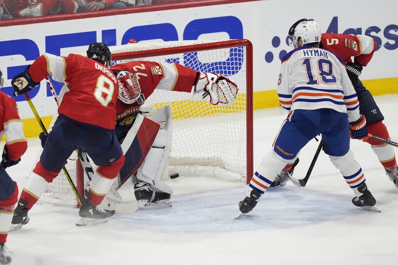 Edmonton Oilers left wing Zach Hyman (18) watches as a shot by center Connor McDavid enters the net for a goal against Florida Panthers goaltender Sergei Bobrovsky (72) during the second period of Game 5 of the NHL hockey Stanley Cup Finals, Tuesday, June 18, 2024, in Sunrise, Fla. (AP Photo/Rebecca Blackwell)