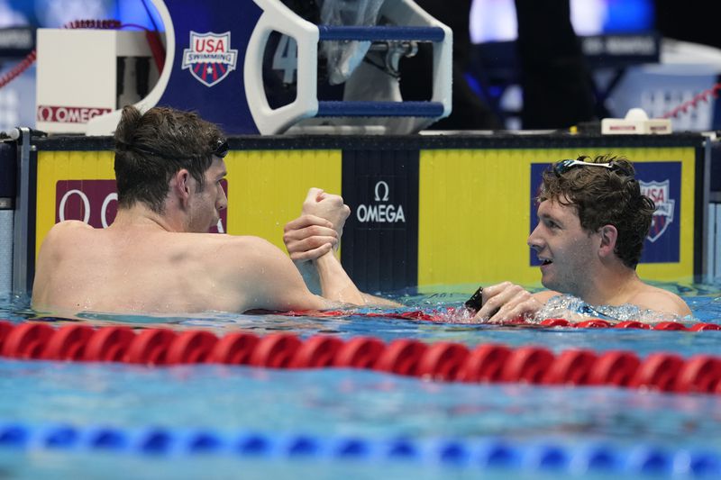 Jack Alexy and Caeleb Dressel shake hands after a Men's 100 freestyle semifinals heat Tuesday, June 18, 2024, at the US Swimming Olympic Trials in Indianapolis. (AP Photo/Darron Cummings)