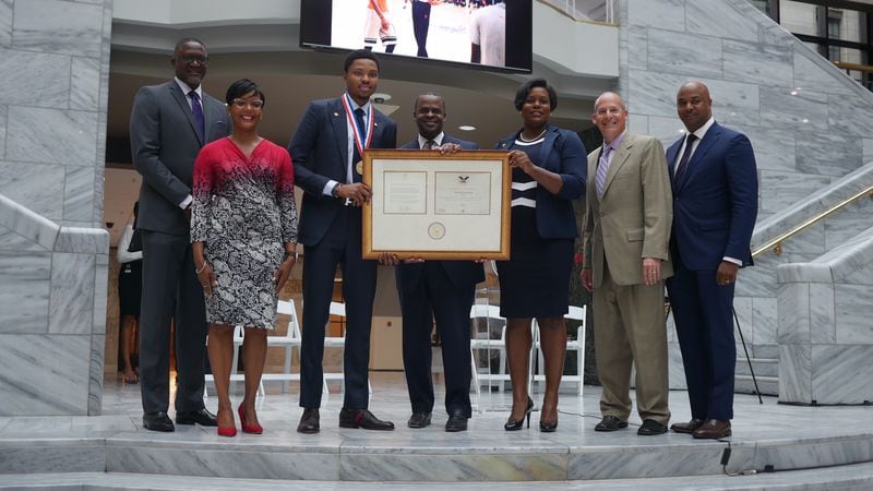 Kent Bazemore (center left) and Atlanta Mayor Kasim Reed (center right) are joined by other who presented in a recent ceremony in which the Hawks player was presented with the Phoenix Award.