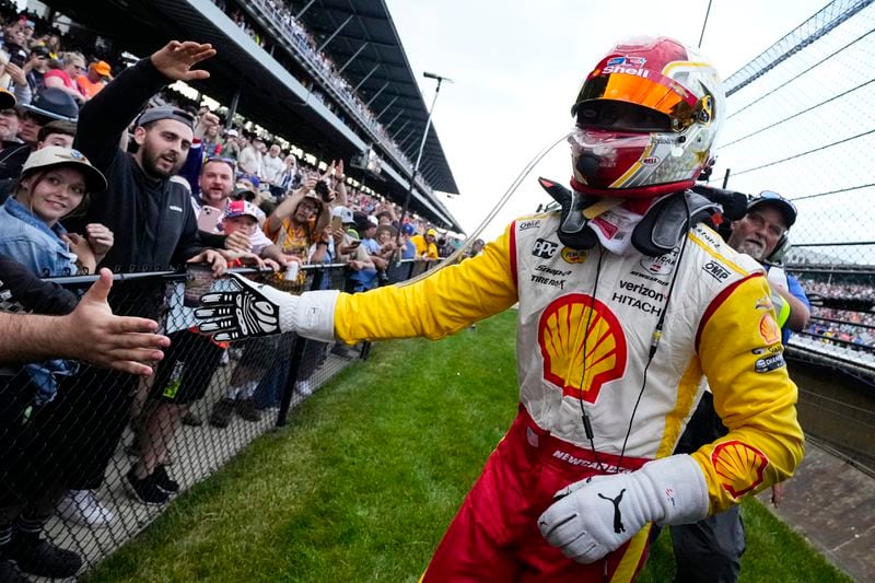 Josef Newgarden celebrates with fans in the stands after winning the Indianapolis 500 auto race at Indianapolis Motor Speedway in Indianapolis, Sunday, May 26, 2024. (AP Photo/AJ Mast)