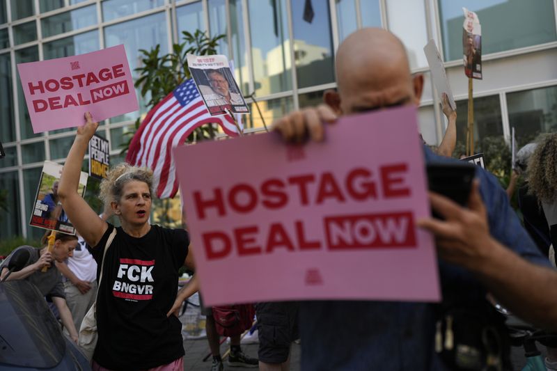 Israelis protest near the hotel where U.S. Secretary of State Antony Blinken is staying during his visit with Israeli Prime Minister Benjamin Netanyahu and leadership about a deal to halt the war in Gaza and free hostages captured by Hamas on Oct. 7 attack, in Tel Aviv, Monday, Aug. 19, 2024. (AP Photo/Ohad Zwigenberg)