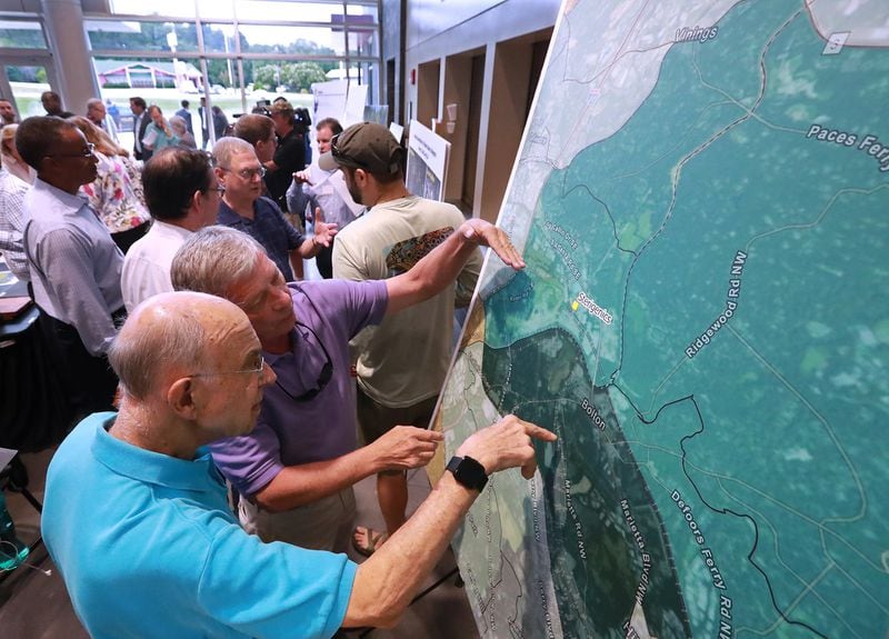 Rick Gross (center) and his neighbor John Keller (left), who live near Sterigenics, look over a map showing estimated cancer risks around the plant site in Cobb County. Gross and Keller were among more than 1,000 people who turned out for a town hall Aug. 19 held by Cobb officials and environmental regulators. CURTIS COMPTON / CCOMPTON@AJC.COM
