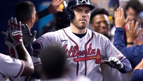 Atlanta Braves' Freddie Freeman is congratulated in the dugout after hitting a two-run home run during the fifth inning of a baseball game against the Miami Marlins, Saturday, July 10, 2021, in Miami. (AP Photo/Lynne Sladky)