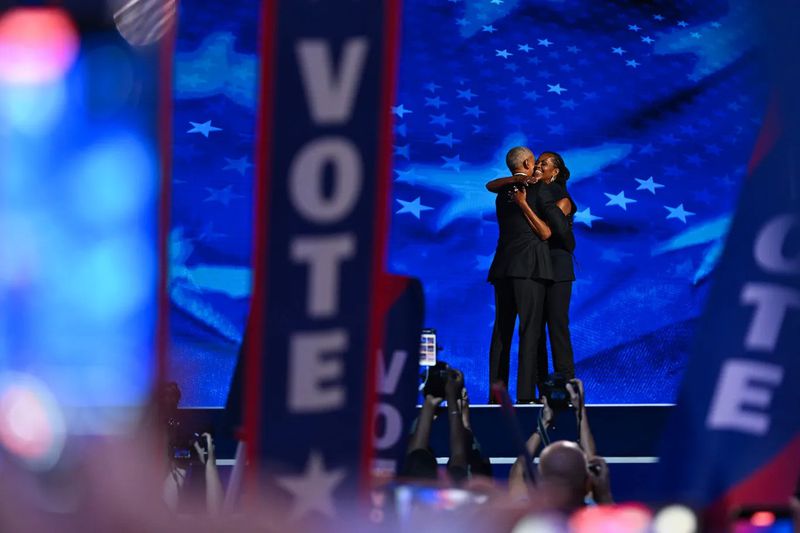 Former President Barack Obama greets former first lady Michelle Obama as he arrives to speak on stage during the second day of the DNC. (COURTESY OF BRANDON BELL/GETTY IMAGES)