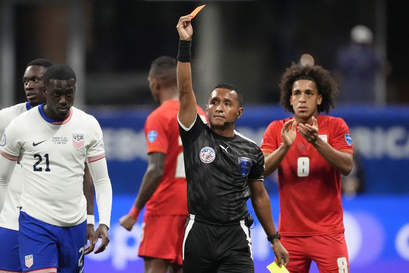 Referee Ivan Barton shows the red card to Tim Weah of the United States, left, during a Copa America Group C soccer match against Panama in Atlanta, Thursday, June 27, 2024. (AP Photo/Mike Stewart)