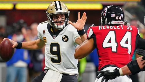 Drew Brees of the Saints attempts to avoid the sack by Falcons defensive end Vic Beasley  Sept. 23, 2018, at Mercedes-Benz Stadium in Atlanta.