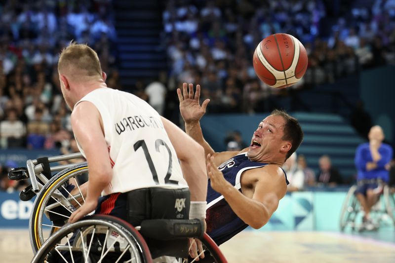 Jake Williams of the U.S. eyes the ball as he falls during the wheelchair basketball men's gold medal match at the 2024 Paralympics, Saturday, Sept. 7, 2024, in Paris, France. (AP Photo/Thomas Padilla)