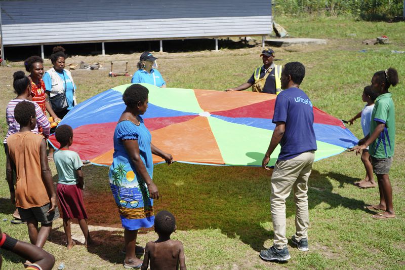 In this undated photo provided by UNICEF PNG, East Sepik massacre survivors play a game at a care center in Angoram, Papua New Guinea. (Noreen Chambers/UNICEF PNG via AP)