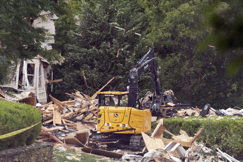 Crew workers remove debris after a house exploded in the Bel Air, Md. neighborhood on Sunday, Aug. 11, 2024. (AP Photo/Jose Luis Magana)