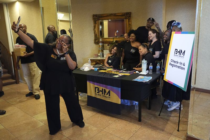 People take a selfie at the Black Health Matters Health Summit and Expo in the Harlem neighborhood of New York, Thursday, Aug. 15, 2024. (AP Photo/Pamela Smith)