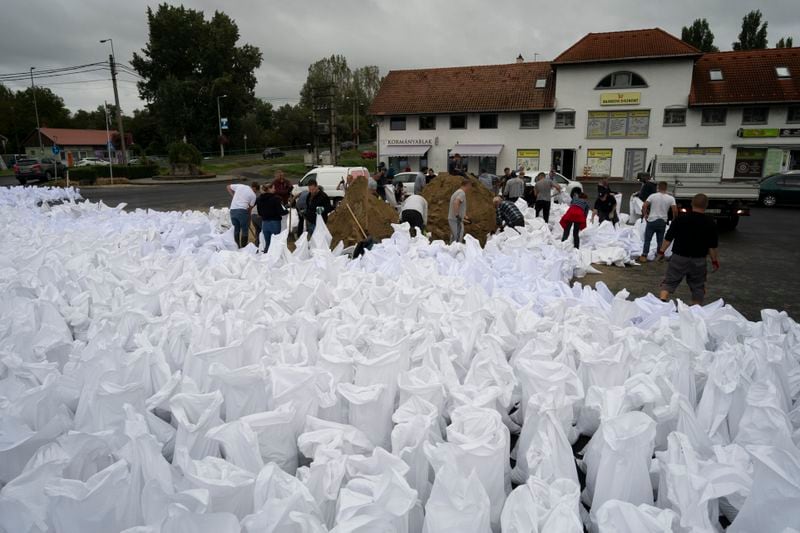 People fill sandbags to reinforce the dam due to the flooding of the Danube river at Tahitotfalu, Hungary, on Monday, Sept. 16, 2024. (AP Photo/Denes Erdos)