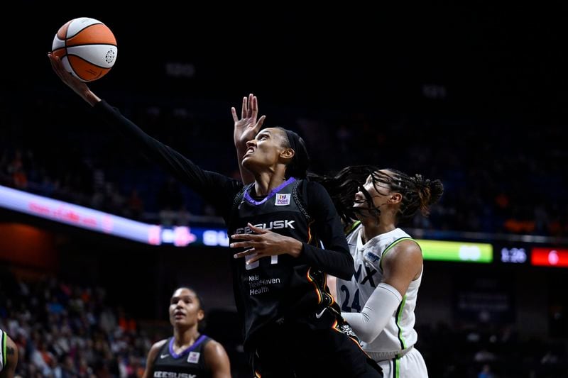 Connecticut Sun forward DeWanna Bonner shoots as Minnesota Lynx forward Napheesa Collier, right, defends during the second half of Game 4 in the WNBA basketball semifinals, Sunday, Oct. 6, 2024, in Uncasville, Conn. (AP Photo/Jessica Hill)