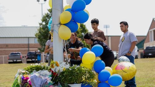 The Mendoza Family from Winder leave flowers and balloons to pay their respects to the victims at Apalachee High School on Thursday, September 5, 2024. This came a day after a 14-year-old opened fire at the Barrow County high school, killing two students and two teachers and injuring nine others. (Miguel Martinez/AJC)