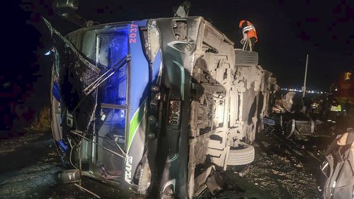 In this handout photo provided by the Peru's Highway Police, rescue workers attend to a bus that collided with a cargo train in La Oroya, Peru, Sunday, May 26, 2024. (Peru's Highway Police, via AP)