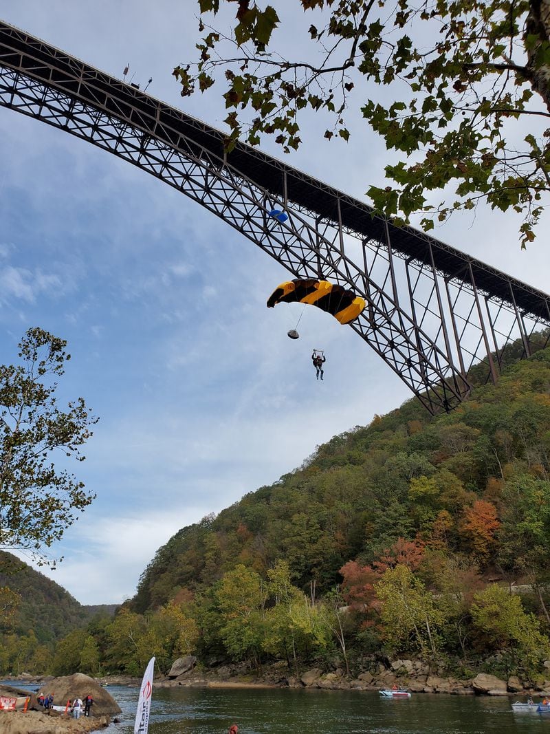 An annual event features jumpers parachuting 876 feet from the New River Gorge Bridge, the longest steel arch span in the Western Hemisphere, to the water at the bottom of the scenic canyon in West Virginia. MUST CREDIT: Bridge Day