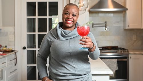 Cheers from Tiffanie Barriere, creator of the Mistletoe Spritz, a refreshing cocktail made with orange juice and a rosemary-cranberry shrub. (Hyosub Shin / Hyosub.Shin@ajc.com)