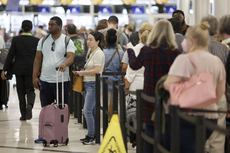 Passengers go through the main security checkpoint for departures at the domestic terminal at Hartsfield-Jackson International Airport on Wednesday. Equipment upgrades at the checkpoint are included in the airport's master plan. (Jason Getz / Jason.Getz@ajc.com)