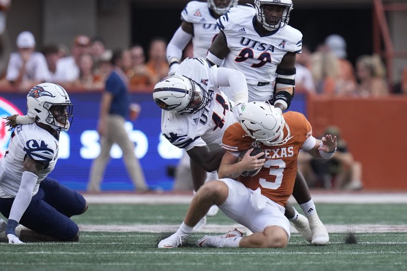 Texas quarterback Quinn Ewers (3) is hit by UTSA defensive lineman Ronald Triplette (44) during the first half of an NCAA college football game in Austin, Texas, Saturday, Sept. 14, 2024. (AP Photo/Eric Gay)