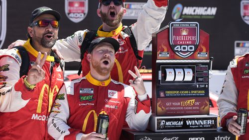 Tyler Reddick and crew stand by the winner's trophy after a NASCAR Cup Series auto race at Michigan International Speedway, Monday, Aug. 19, 2024, in Brooklyn, Mich. (AP Photo/Carlos Osorio)