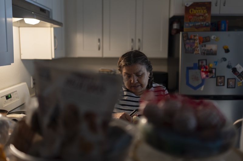 Marina Maalouf, a longtime resident of Hillside Villa who participated in protests after rents doubled in 2019, peels potatoes in her apartment in Los Angeles, Tuesday, Oct. 1, 2024. (AP Photo/Jae C. Hong)