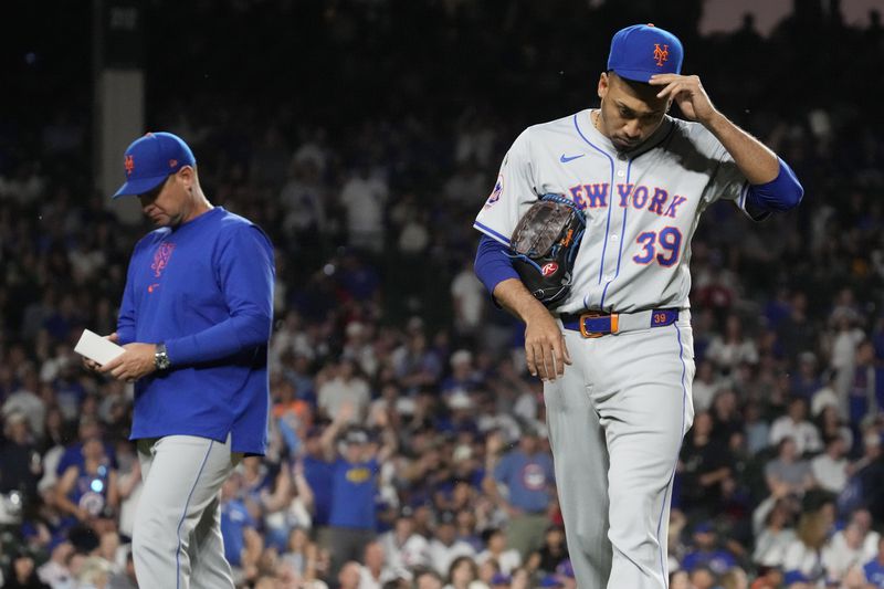New York Mets relief pitcher Edwin Díaz, right, reacts after being ejected by their base umpire Vic Carapazza as manager Carlos Mendoza looks down as he walks to the dugout during the ninth inning of a baseball game against the Chicago Cubs in Chicago, Sunday, June 23, 2024. (AP Photo/Nam Y. Huh)