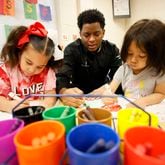 Pre-K students Dior Thomas (left), 5, and Andrea Medina-Espericueta, 5, work with teacher Johnathon Hines during playtime at Barack H. Obama Elementary Magnet School of Technology on Tuesday, Feb. 14, 2023. (Miguel Martinez / miguel.martinezjimenez@ajc.com)