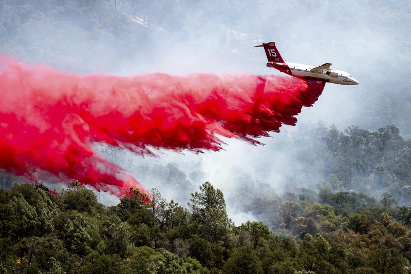 An air tanker drops retardant while trying to stop the Thompson Fire from spreading in Oroville, Calif., Wednesday, July 3, 2024. An extended heatwave blanketing Northern California has resulted in red flag fire warnings and power shutoffs. (AP Photo/Noah Berger)