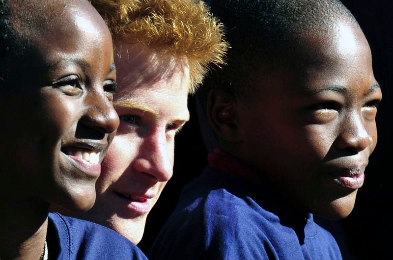 FILE - Britain's Prince Harry poses with children from the Mophane Primary school, in Gaborone, Botswana, Tuesday, June 15, 2010. (AP Photo/Shayne Robinson, File)