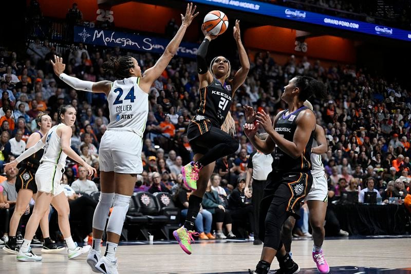 Connecticut Sun guard DiJonai Carrington (21) shoots over Minnesota Lynx forward Napheesa Collier (24) during the second half of a WNBA basketball semifinal game, Friday, Oct. 4, 2024, in Uncasville, Conn. (AP Photo/Jessica Hill)