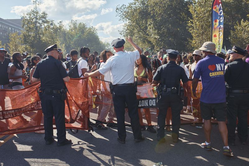 Police move revelers from the street after a shooting on Eastern Parkway, near the corner of Franklin Avenue, during the West Indian Day Parade on Monday, Sept. 2, 2024, in the Brooklyn borough of New York. (AP Photo/Andres Kudacki)