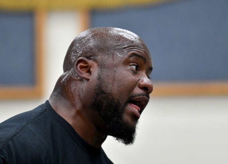 Twiggs County High School band director Ernest Stackhouse leading practice on a summer day. (Hyosub Shin / AJC)