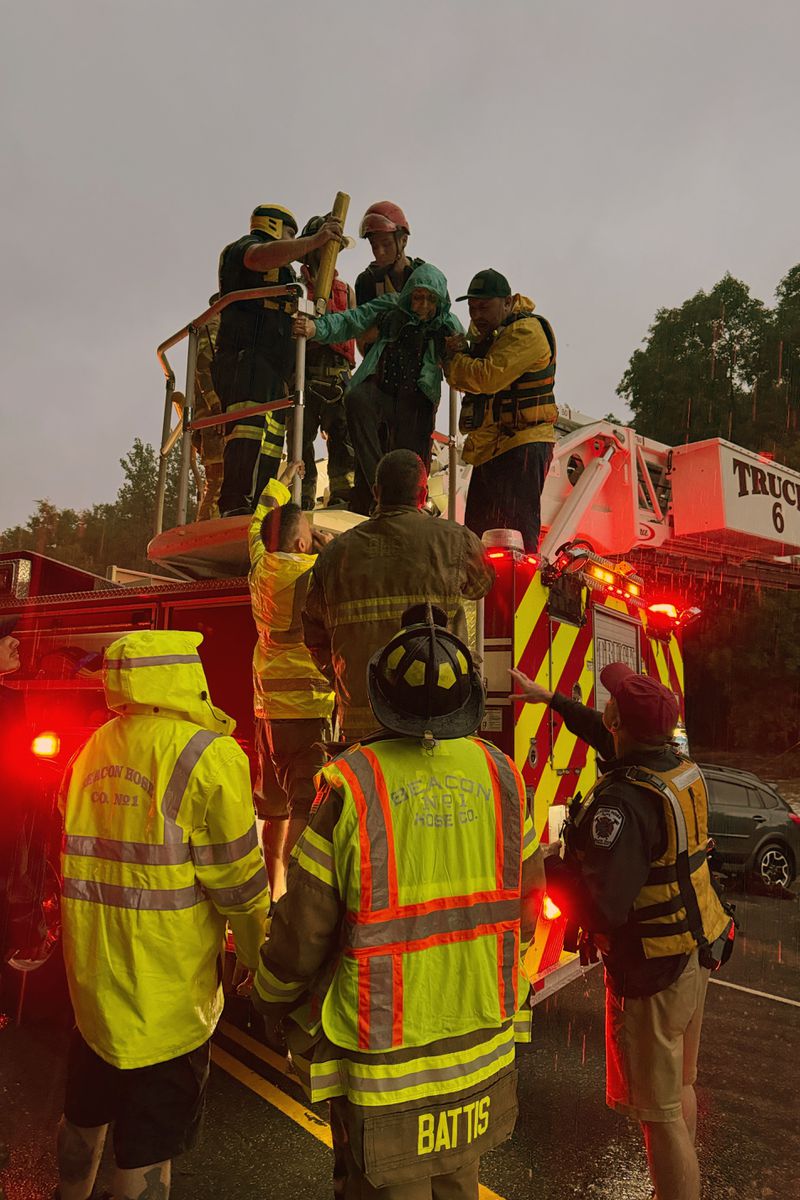 This photo provided by Beacon Hose Co. No. 1, a fire station in Beacon Falls, Connecticut, shows members of Beacon Hose Co. rescuing people from the Brookside Inn in Oxford, Conn., Sunday, Aug. 18, 2024. (Beacon Hose Co via AP)