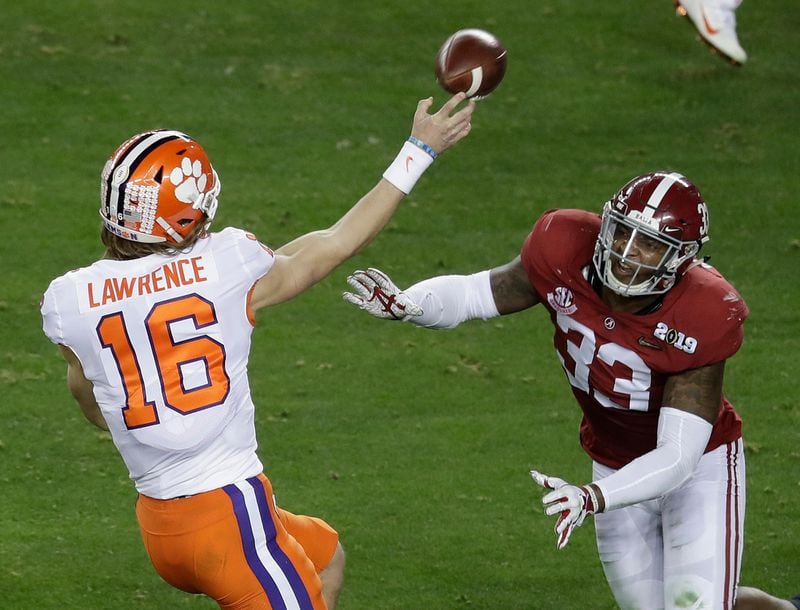 Clemson's Trevor Lawrence throws while being rushed by Alabama's Anfernee Jennings during the first half of the NCAA college football playoff championship game, Monday, Jan. 7, 2019, in Santa Clara, Calif.