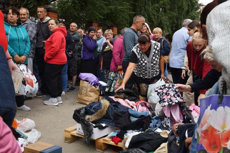 People evacuated from fighting between Russian and Ukrainian forces queue to receive humanitarian aid at a distribution center in Kursk, Russia, Monday, Aug. 12, 2024. (AP Photo)