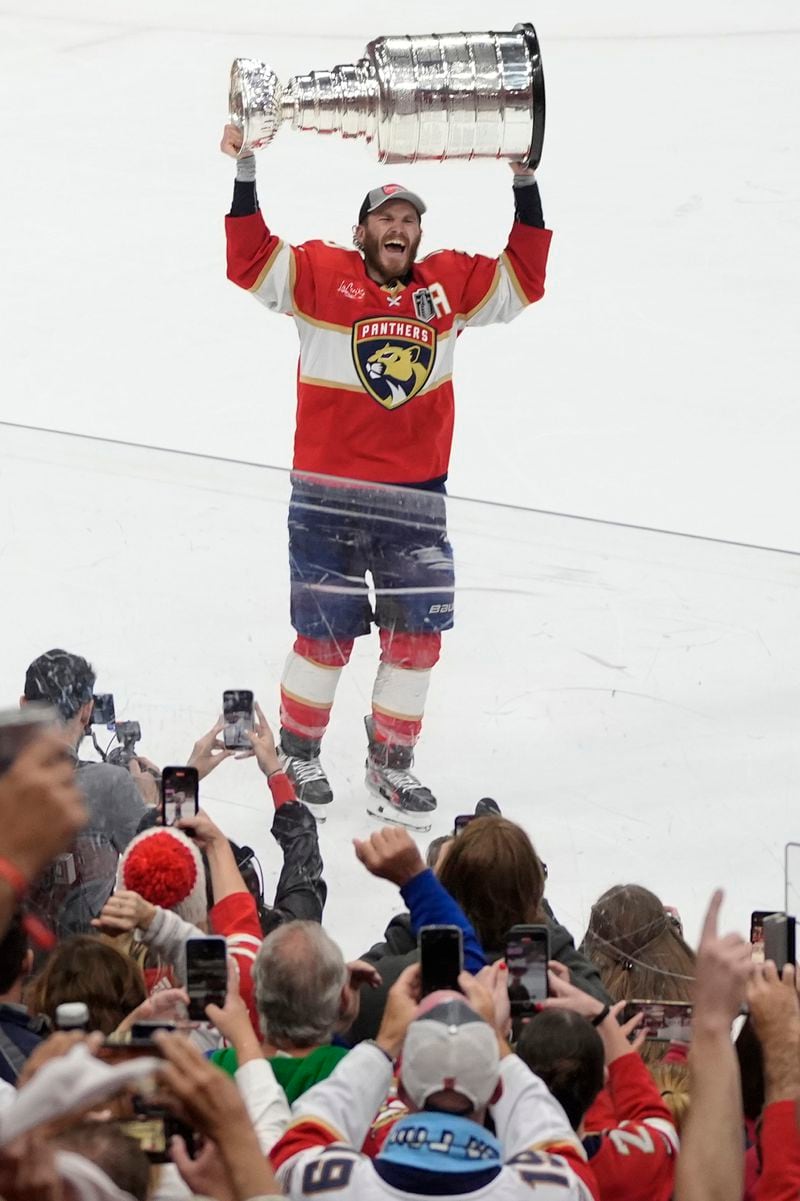 Florida Panthers left wing Matthew Tkachuk raises the Stanley Cup trophy after defeating the Edmonton Oilers in Game 7 of the NHL hockey Stanley Cup Final, Monday, June 24, 2024, in Sunrise, Fla. The Panthers defeated the Oilers 2-1. (AP Photo/Rebecca Blackwell)