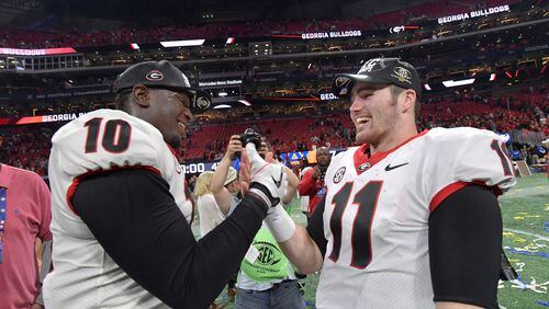 December 2, 2017 Atlanta: Georgia defensive lineman Malik Herring (10) and Georgia quarterback Jake Fromm (11) celebrate after their victory over the Auburn during the Southeastern Conference championship NCAA college football game at Mercedes-Benz Stadium, December 2, 2017, in Atlanta.  Hyosub Shin / hshin@ajc.com