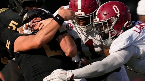 Vanderbilt quarterback Diego Pavia, left, is tackled by Alabama linebacker Jihaad Campbell (11) and linebacker Deontae Lawson (0) during the first half of an NCAA college football game Saturday, Oct. 5, 2024, in Nashville, Tenn. (AP Photo/George Walker IV)